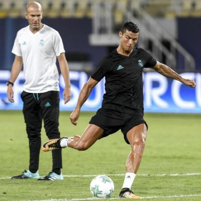 Real Madrids French head coach Zinedine Zidane (L) looks on as Real Madrids forward Cristiano Ronaldo shoots the ball during a training session before the UEFA Super Cup 2017 football match between Real Madrid and Manchester United at the National Arena Filip II on August 7, 2017 in Skopje. / AFP PHOTO / NIKOLAY DOYCHINOV