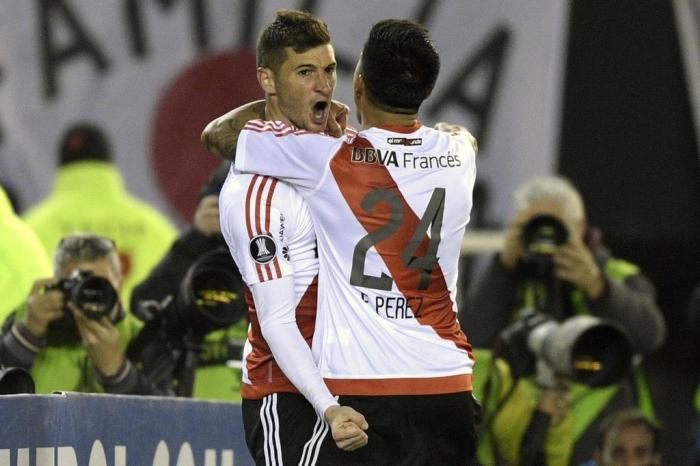 Argentinas River Plate forward Lucas Alario (L) celebrates with midfielder Enzo Perez after scoring against Paraguays Guarani during their Copa Libertadores 2017 round before the quarterfinals second leg football match at the Monumental stadium in Buenos Aires, Argentina, on August 8, 2017. / AFP PHOTO / JUAN MABROMATA