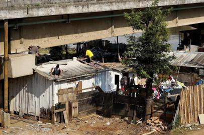 PORTO ALEGRE, RS, BRASIL, 24-08-2017: Moradores das margens da BR-116, na Ilha do Pavão, desmancham uma casa para se mudar para outro local. Diversas famílias tiveram suas residências destruídas e agora vivem em condições precárias em um galpão abandonado. (Foto: Mateus Bruxel / Agência RBS)