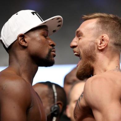 LAS VEGAS, NV - AUGUST 25: Boxer Floyd Mayweather Jr. (L) and UFC lightweight champion Conor McGregor face off during their official weigh-in at T-Mobile Arena on August 25, 2017 in Las Vegas, Nevada. The two will meet in a super welterweight boxing match at T-Mobile Arena on August 26.   Christian Petersen/Getty Images/AFP