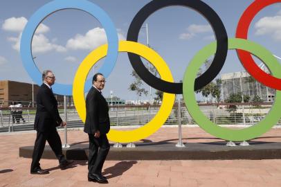 French President Francois Hollande (R) and President of the Brazilian Olympic Committee Carlos Arthur Nuzman walk in front of the Olympic rings during Hollandes visit to attend the Rio 2016 Olympics in Rio de Janeiro on August 4, 2016. / AFP PHOTO / POOL / JACK GUEZ