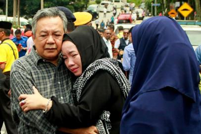 Nik Azlan Nik Abdul Kadir (L), pai de uma das vítimas, conforta sua esposa fora da escola religiosa Darul Quran Ittifaqiyah em Kuala Lumpur, em 14 de setembro de 2017.
Vinte e quatro pessoas, na sua maioria jovens adolescentes, foram mortas no dia 14 de setembro, quando uma incursão rasgou uma escola religiosa da Malásia, o que as autoridades disseram que foi um dos piores desastres de fogo do país há anos. / AFP PHOTO / SADIQ ASYRAF