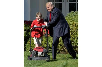 US President Donald Trump pats Frank Giaccio, 11, of Falls Church, Virginia, on the back as he mows the lawn in the Rose Garden of the White House on September 15, 2017, in Washington, DC.                 
Giaccio, who has his own lawn mowing business wrote a letter to the President asking if he could mow the lawn at the White House.  / AFP PHOTO / Mike Theiler