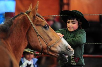  CAXIAS DO SUL, RS, BRASIL, 15/09/2017. Tradicionalismo. Gabriel Cardoso, 8 anos, está no acampamento farroupilha, no Pavilhões da Festa da Uva. Na foto, junto da cancha de rodeios. Ele está aproveitando a Semana Farroupilha junto com seu pai, Ricardo Cardoso. (Porthus Junior/Agência RBS)