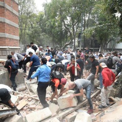 People remove debris of a damaged building after a real quake rattled Mexico City on September 19, 2017 while an earthquake drill was being held in the capital.
A powerful earthquake shook Mexico City on Tuesday, causing panic among the megalopolis 20 million inhabitants on the 32nd anniversary of a devastating 1985 quake. The US Geological Survey put the quakes magnitude at 7.1 while Mexicos Seismological Institute said it measured 6.8 on its scale. The institute said the quakes epicenter was seven kilometers west of Chiautla de Tapia, in the neighboring state of Puebla.
 / AFP PHOTO / Alfredo ESTRELLA