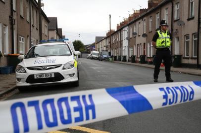 A police officer stands guard at a police cordon near to a house in Newport, south Wales, on September 20, 2017, as they continue their investigations into the September 15 terror attack on a London underground tube train carriage attack at Parsons Green station.
Two men were arrested in Wales on Wednesday over last weeks London Underground terror attack in which 30 people were injured, bringing the total number of people in custody to five, police said. The men, aged 48 and 30, were arrested under anti-terrorism legislation in Newport in Wales, police said, after a 25-year-old man was arrested in the same city on Tuesday. / AFP PHOTO / GEOFF CADDICK