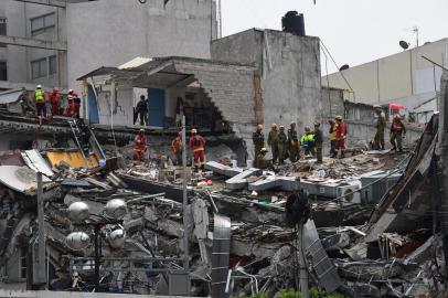  Equipes de resgate procuram sobreviventes em um prédio que desabou após terremoto que atingiu a cidade no dia 19/09. Um poderoso terremoto de 7.1 sacudiu a Cidade do México na terça-feira, causando pânico entre os 20 milhões de habitantes da megalópole no 32º aniversário de um devastador terremoto de 1985.Rescuers from Mexico and Israel (olive green) search for survivors in a flattened building in Mexico City on September 21, 2017 two days after a strong quake hit central Mexico.A powerful 7.1 earthquake shook Mexico City on Tuesday, causing panic among the megalopolis 20 million inhabitants on the 32nd anniversary of a devastating 1985 quake. / AFP PHOTO / Ronaldo SCHEMIDTEditoria: DISLocal: Mexico CityIndexador: RONALDO SCHEMIDTSecao: earthquakeFonte: AFPFotógrafo: STF