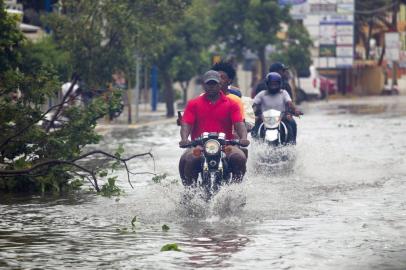 Men ride motorcyles along a flooded street in Punta Cana, in the Dominican Republic, as Hurricane Maria approaches on September 20, 2017. 
The government of the Dominican Republic told people to stay home from their public and private sector jobs on Thursday, when the hurricane is expected to hit the island.  / AFP PHOTO / Erika SANTELICES