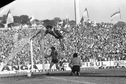  O "gol do salto"FINAL - Gre-Nal ¿ Campeonato Gaúcho de 1977.Grêmio 1 x 0 InterGrêmio Campeão Gaúcho de 1977.Depois de oito anos, o Grêmio, ao vencer o Inter por 1 a0, no dia 25/09/1977, no Olímpico, sagrou-se campeão gaúcho. André Catimba, aos 42 minutos do primeiro tempo, fez o gol. Na comemoração, ¿o gol do salto¿, acabou se machucado.Um tumulto no fim do Gre-Nal antecipou o término da partida.Árbitro:  Luiz Torres (levou uma voadora nas costas).Tocida:  torcedores exaltados pularam o fosso e invadiram o campo.-#ENVELOPE: 122820