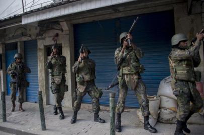  

Soldiers take part in a joint operation by the Police and Brazilian Armed Forces to fight heavily armed drug traffickers at the Rocinha favela in Rio de Janeiro, Brazil, on September 22, 2017.
Brazilian soldiers were sent to help Rio de Janeiro police fight heavily armed drug traffickers who have taken over much of the biggest shantytown in the country, the Rocinha favela. Local media reported intense shooting between police and criminals early Friday at Rocinha, where approximately 70,000 people live in a teeming collection of small homes on steep hillsides overlooking western Rio. / AFP PHOTO / Mauro PIMENTEL

Editoria: CLJ
Local: Rio de Janeiro
Indexador: MAURO PIMENTEL
Secao: police
Fonte: AFP
Fotógrafo: STF