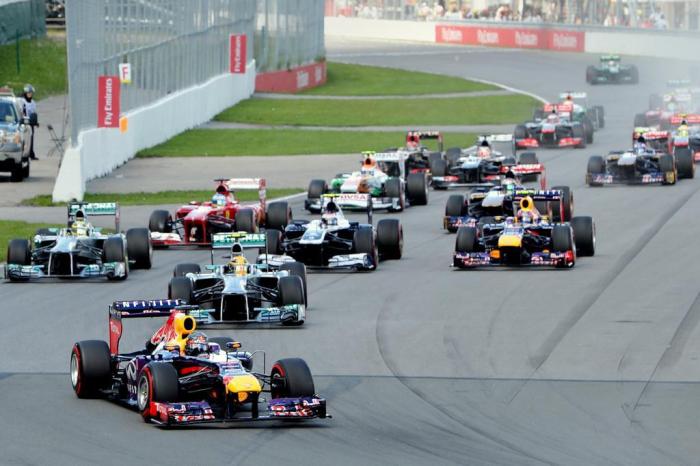 Red Bull driver Sebastian Vettel of Germany (L) leads the grid into the first turn at the start of the Canadian Formula One Grand Prix at the Circuit Gilles Villeneuve in Montreal on June 9, 2013.    AFP PHOTO/Stan HONDA