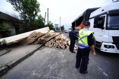  PORTO ALEGRE, RS, BRASIL - 29-09-2017 - Carga de madeira tomba de caminhão e interrompe trânsito na Zona Norte. Acidente ocorreu na Avenida Bernardino Silveira Amorim e derrubou portão de uma casa. Tráfego no sentido Centro-bairro é totalmente interrompido para remoção da carga.