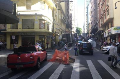 Um problema em um bueiro está causando transtornos no trânsito na Rua Doutor Flores, no bairro Centro Histórico, em Porto Alegre. O buraco está bloqueando parcialmente o cruzamento da via com a Rua dos Andradas.