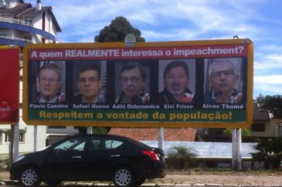 Outdoor com fotos dos cinco vereadores que votaram pela admissibilidade do impeachment do prefeito Daniel Guerra (PRB): Flavio Cassina (PTB), Rafael Bueno (PDT), Adiló Didomenico (PTB), Elói Frizzo (PSB) e Alceu Thomé (PTB)