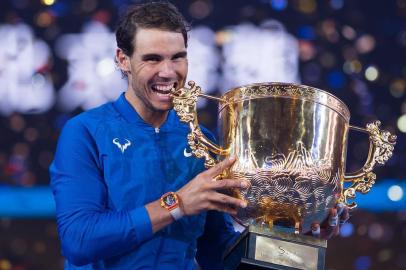 Rafael Nadal of Spain holds the trophy after winning the mens singles final match against Nick Kyrgios of Australia at the China Open tennis tournament in Beijing on October 8, 2017. / AFP PHOTO / NICOLAS ASFOURI