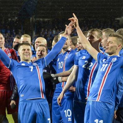 Icelands players including Icelands forward Johann Berg Gudmundsson (L) and Icelands forward Alfred Finnbogason celebrate after the FIFA World Cup 2018 qualification football match between Iceland and Kosovo in Reykjavik, Iceland on October 9, 2017.
Iceland qualified for the FIFA World Cup 2018 as smallest country ever after beating Kosovo 2-0 at home in Reykjavik. / AFP PHOTO / Haraldur Gudjonsson / ALTERNATIVE CROP 