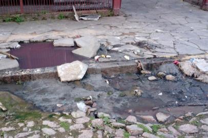 Um buraco na Rua Luiz Cezar Leal, no bairro Rubem Berta, em Porto Alegre, está prejudicando moradores da região. Segundo um usuário do aplicativo Pelas Ruas, o problema localiza-se em frente ao portão de garagem de um prédio residencial.