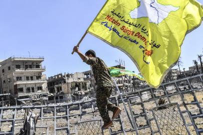  

A member of the Syrian Democratic Forces (SDF), backed by US special forces, holds up his groups flag at the iconic Al-Naim square in Raqa on October 17, 2017.
US-backed forces said they had taken full control of Raqa from the Islamic State group, defeating the last jihadist holdouts in the de facto Syrian capital of their now-shattered caliphate. / AFP PHOTO / BULENT KILIC

Editoria: WAR
Local: Raqa
Indexador: BULENT KILIC
Secao: war
Fonte: AFP
Fotógrafo: STF