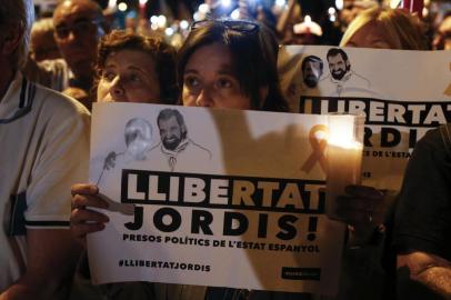 A woman holds a candle during a demonstration in Barcelona against the arrest of two Catalan separatist leaders on October 17, 2017.
Catalonia braced for protests after a judge ordered the detention of two powerful separatist leaders, further inflaming tensions in the crisis over the Spanish regions chaotic independence referendum. / AFP PHOTO / PAU BARRENA