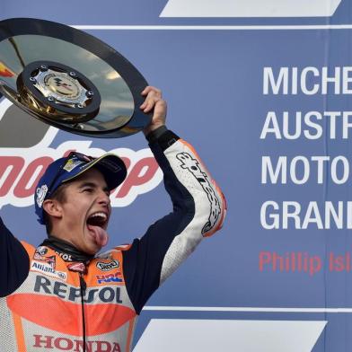 Honda rider Marc Marquez of Spain celebrates his victory on the podium at the end of the Australian MotoGP Grand Prix at Phillip Island on October 22, 2017. / AFP PHOTO / PETER PARKS / -- IMAGE RESTRICTED TO EDITORIAL USE - STRICTLY NO COMMERCIAL USE --