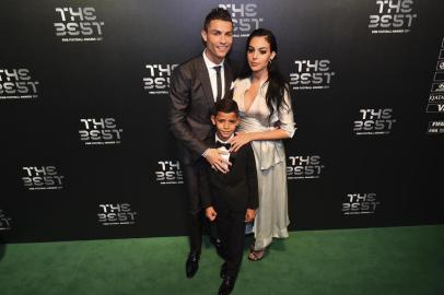 Real Madrid and Portugal forward Cristiano Ronaldo (L) poses for a photograph with partner Georgina Rodriguez (R) and his son Cristiano Ronaldo Jr as he arrives for The Best FIFA Football Awards ceremony, on October 23, 2017 in London. / AFP PHOTO / Glyn KIRK