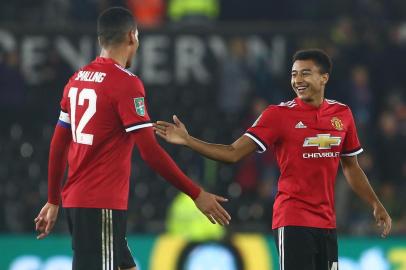 Manchester Uniteds English defender Chris Smalling (L) and Manchester Uniteds English midfielder Jesse Lingard applauds the fans following the English League Cup fourth round football match between Swansea City and Manchester United at The Liberty Stadium in Swansea, south Wales on October 24, 2017. / AFP PHOTO / Geoff CADDICK / RESTRICTED TO EDITORIAL USE. No use with unauthorized audio, video, data, fixture lists, club/league logos or live services. Online in-match use limited to 75 images, no video emulation. No use in betting, games or single club/league/player publications.  / 