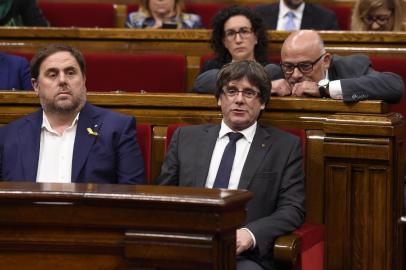 Catalan president Carles Puigdemont (C) and Catalan regional vice president and chief of economy and finance Oriol Junqueras attend a session at the Catalan parliament in Barcelona on October 26, 2017.
Catalan leader Carles Puigdemont said today he had considered calling elections to prevent Madrid from seizing control of the region, but decided there were no guarantees to do so. He went on to say that it was now up to the (regional) parliament to decide on how to respond to the central governments planned takeover of Catalan political powers following an outlawed independence referendum.



 / AFP PHOTO / Josep LAGO