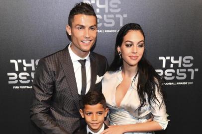 Real Madrid and Portugal forward Cristiano Ronaldo (L) poses for a photograph with partner Georgina Rodriguez (R) and his son Cristiano Ronaldo Jr as he arrives for The Best FIFA Football Awards ceremony, on October 23, 2017 in London. / AFP PHOTO / Glyn KIRK