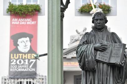  

A statue of German Church reformer Martin Luther holding a book including his translation into German of the New Testament of the Bible is pictured at the main square in front of the city hall in Wittenberg, eastern Germany, where celebrations take place on the occasion of the 500th anniversary of the Reformation on October 31, 2017.
It is presumed that October 31, 1517 is the date that German theologian Martin Luther published his groundbreaking "95 Theses" of criticism of the Catholic Church, which marks the start of the process that led Protestants to break away from the Roman Catholic Church, a revolution for the Christian religion. The Reformation caused major upheaval in Europe, leading to wars, persecutions and exoduses, including the departure of the Pilgrims for what was later to become America. / AFP PHOTO / John MACDOUGALL

Editoria: REL
Local: Wittenberg
Indexador: JOHN MACDOUGALL
Secao: religious festival or holiday
Fonte: AFP
Fotógrafo: STF