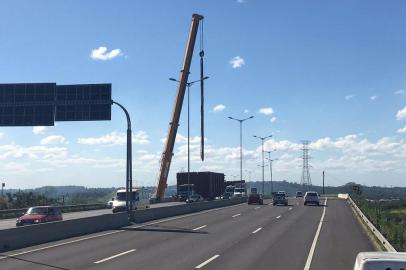 O trânsito no sentido Interior-Capital da Rodovia do Parque está parcialmente bloqueado, em Canoas, para uma operação de descarga de placas de 7 metros que foram transportadas por dois caminhões até uma empresa que fica nas margens da BR-448, na altura do km 13. 