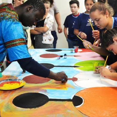 Alunos da Associação Criança Feliz de Caxias em oficina de criação coletiva com temática voltada à África. A aula especial foi ministrada pelo artista plástico senegalês Ousmane Mathurin Ndiaye.