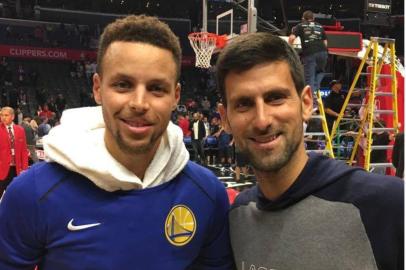 O armador Stephen Curry, do Golden State Warriors, posa para foto com o tenista sérvio Novak Djokovic, antes do jogo do time de Oakland contra o LA Clippers, em Los Angeles. 