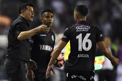 The coach of Argentina's Lanus, Jorge Almiron (L), speask to players during their Copa Libertadores semifinal second leg football match against Argentina's River Plate in Lanus, on the outskirts of Buenos Aires, on October 31, 2017. / AFP PHOTO / Juan MABROMATA