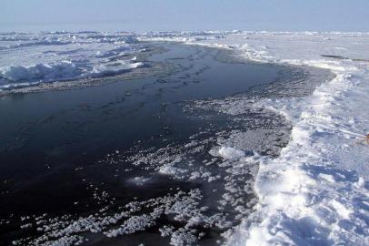 #PÁGINA:08Antigas culturas desaparecem à medida que se derrete o gelo do ÁrticoO degelo abre um espaço e a água aflora revelando o Oceano ÁrticoARCTIC(NYT16) AT THE NORTH POLE -- Oct. 24, 2005 -- SCI-ARCTIC-ICE -- At the North Pole, an open-water gap, or lead, widened sharply in the space of a few hours near Camp Borneo, pictured in 2004, separating the tents from the helicopter landing area. The board at right had once bridged the gap. Bright Arctic ocean ice reflects sunlight, but open dark water absorbs it, warming in the process. As more ice melts, more open water could amplify the warming trend. (Andrew C. Revkin/The New York Times) Fonte: NYT Fotógrafo: Andrew C. Revkin