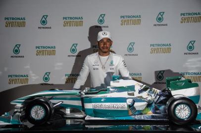 F1 World Champion, Mercedes British driver Lewis Hamilton, poses behind a replica of a Mercedes racing car customized with an image of late Brazilian F1 driver Ayrton Senna, after a press conference in Sao Paulo, Brazil, on November 8, 2017 ahead of Sundays Formula One Brazilian Grand Prix. / AFP PHOTO / Nelson ALMEIDA