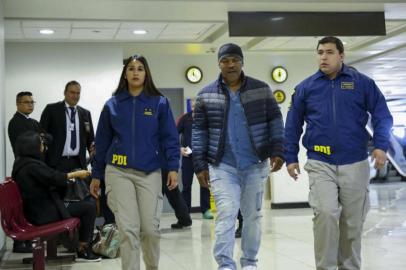 Handout picture realesed on November 9, 2017 by Chiles Investigation Police showing US former world heavyweight boxing champion Mike Tyson escorted by Chiles Investigations Police members at Santiago de Chile airport.
Tyson was detained at the airport for violating Chilean immigration laws and he will be deported to the United States.   / AFP PHOTO / CHILES INVESTIGATIONS POLICE / HO / RESTRICTED TO EDITORIAL USE - MANDATORY CREDIT AFP PHOTO / CHILES INVESTIGATIONS POLICE  - NO MARKETING - NO ADVERTISING CAMPAIGNS - DISTRIBUTED AS A SERVICE TO CLIENTS

