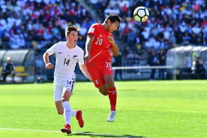 Perus Edison Flores (R) controls the ball next to New Zealands Ryan Thomas during the World Cup football qualifying match between New Zealand and Peru at Westpac Stadium in Wellington on November 11, 2017.  / AFP PHOTO / Marty MELVILLE