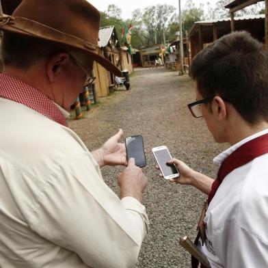  

PORTO ALEGRE, RS, BRASIL, 10-09-2017. Acampamento Farroupilha. App do Acampamento, que é um esforço do MTG para se modernizar. Sérgio Maroski (D), divulgador do app, intrui o jovem Roger Guedes, 17.   (CARLOS MACEDO/AGÊNCIA RBS)