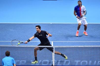 Brazils Marcelo Melo (L) and Polands Lukasz Kubot return against Finlands Henri Kontinen and Australias John Peers during their mens doubles final match on day eight of the ATP World Tour Finals tennis tournament at the O2 Arena in London on November 19, 2017. / AFP PHOTO / Glyn KIRK