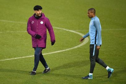 Manchester Citys Spanish manager Pep Guardiola (L) gestures as he talks with Manchester Citys Brazilian midfielder Fernandinho during a team training session at the City Football Academy in Manchester, north west England on November 20, 2017, on the eve of their UEFA Champions League Group F match against Feyenoord. / AFP PHOTO / Oli SCARFF