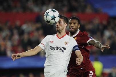 Sevillas defender Sergio Escudero (L) vies with Liverpools Dutch midfielder Georginio Wijnaldum (R) on November 21, 2017 at the Ramon Sanchez Pizjuan stadium in Sevilla during the UEFA Champions League group E football match between Sevilla FC and Liverpool FC. The match ended in a draw 3-3. / AFP PHOTO / CRISTINA QUICLER