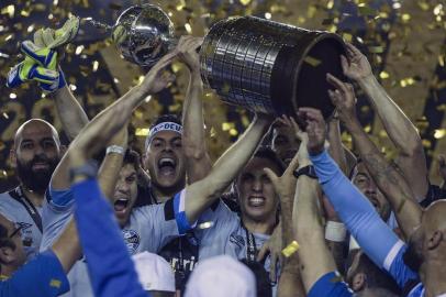  Brazil's Gremio footballers celebrate with the trophy after winning the Copa Libertadores 2017 final football match against Argentina's Lanus at Lanus stadium in Lanus, Buenos Aires, Argentina, on November 29, 2017. Gremio won 2-1 to become the champion of the Copa Libertadores 2017. / AFP PHOTO / JUAN MABROMATAEditoria: SPOLocal: Buenos AiresIndexador: JUAN MABROMATASecao: soccerFonte: AFPFotógrafo: STF