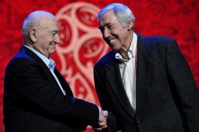 Draw assistants: Nikita Simonyan (L), former USSR forward and coach, shakes hands with Gordon Banks, former Englands goalkeeper, as they pose on the stage of the State Kremlin Palace in Moscow on November 30, 2017 on the eve of the Final Draw for the 2018 FIFA World Cup. / AFP PHOTO / Mladen ANTONOV