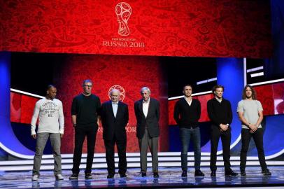 From L: Draw assistants: Cafu, former Brazils footballer, Laurent Blanc, former Frances defender and former Paris Saint-Germains coach, Nikita Simonyan, former USSR forward and coach, Gordon Banks, former Englands goalkeeper, Fabio Cannavaro, former Italys defender and Guangzhou Evergrandes coach, Diego Forlan, former Uruguays forward, and Carles Puyol, former Spains defender, pose on the stage of the State Kremlin Palace in Moscow on November 30, 2017 on the eve of the Final Draw for the 2018 FIFA World Cup. / AFP PHOTO / Mladen ANTONOV