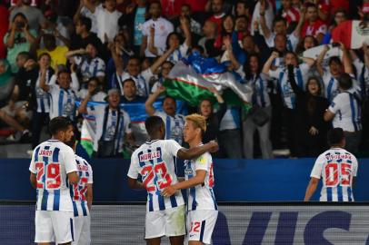 CF Pachucas Mexican midfielder Victor Guzman (R) celebrates after scoring a goal against Wydad Casablanca as his Mexican teammate Oscar Murillo (C-L) embraces Japanese teammate Keisuke Honda (C-R), during their FIFA Club World Cup quarter-final match at Zayed Sports City Stadium in the Emirati capital Abu Dhabi on December 9, 2017. / AFP PHOTO / GIUSEPPE CACACE