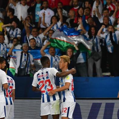 CF Pachucas Mexican midfielder Victor Guzman (R) celebrates after scoring a goal against Wydad Casablanca as his Mexican teammate Oscar Murillo (C-L) embraces Japanese teammate Keisuke Honda (C-R), during their FIFA Club World Cup quarter-final match at Zayed Sports City Stadium in the Emirati capital Abu Dhabi on December 9, 2017. / AFP PHOTO / GIUSEPPE CACACE