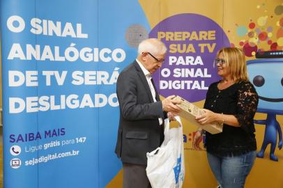  

PORTO ALEGRE, RS, BRASIL, 12-12-2017: Desligamento do sinal analógico da TV aberta e a implantação da TV digital no Rio Grande do Sul. Na foto, Juarez Quadros, Presidente da Anatel, entrega kit para Márcia Rodrigues Witt, 47 anos, beneficiária do Bolsa Família (FOTO FÉLIX ZUCCO/AGÊNCIA RBS, Editoria de Notícias).