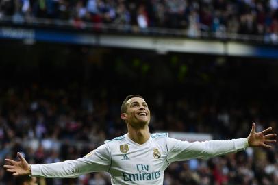 Real Madrids Portuguese forward Cristiano Ronaldo celebrates after scoring a goal during the Spanish league football match between Real Madrid and Sevilla at the Santiago Bernabeu Stadium in Madrid on December 9, 2017. / AFP PHOTO / PIERRE-PHILIPPE MARCOU