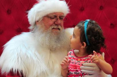  CAXIAS DO SUL, RS, BRASIL, 14/12/2017. Presente de Natal - Matéria do Almanaque sobre os pedidos mais frequentes aos Papais Noéis. Na foto, o Papai Noel do shopping Iguatemi Caxias com Maria Isabel Sales, dois anos. (Porthus Junior/Agência RBS)