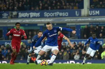 Evertons English striker Wayne Rooney takes a penalty and scores the third goal during the English Premier League football match between Everton and Swansea City at Goodison Park in Liverpool, north west England on December 18, 2017. / AFP PHOTO / PAUL ELLIS / RESTRICTED TO EDITORIAL USE. No use with unauthorized audio, video, data, fixture lists, club/league logos or live services. Online in-match use limited to 75 images, no video emulation. No use in betting, games or single club/league/player publications.  / 